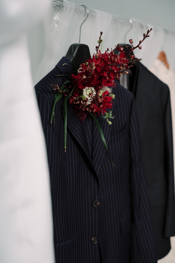 Cận cảnh hoa cài áo Boutonnière đỏ thẫm trên ve áo nhọn