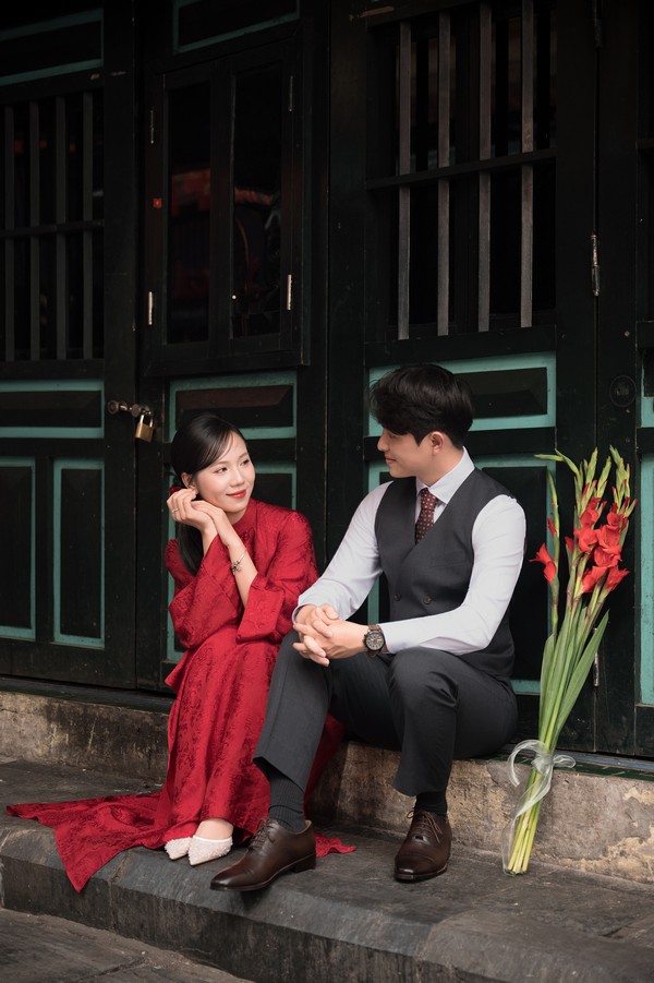 Ngồi tự nhiên bên thềm nhà phố cổ cùng bó lay ơn đỏ