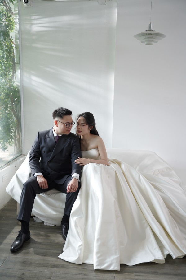 Chú rể ngắm nhìn cô dâu bên khung kính tràn ngập ánh sáng tự nhiên